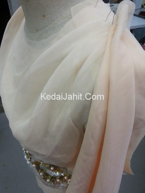 Applique mula disusun pada bahagian baju